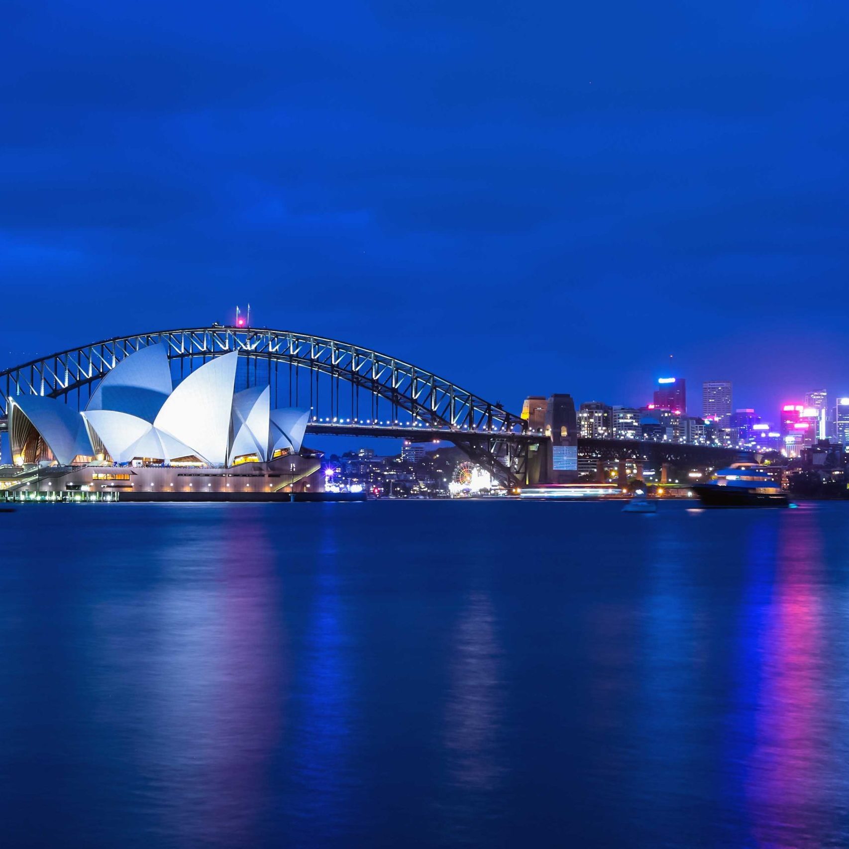 Opera House and Harbor Bridge at twilight view from Mrs. Macquarie's chair viewpoint.